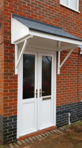 White PVCu door & sidescreen with GRP porch canopy above
